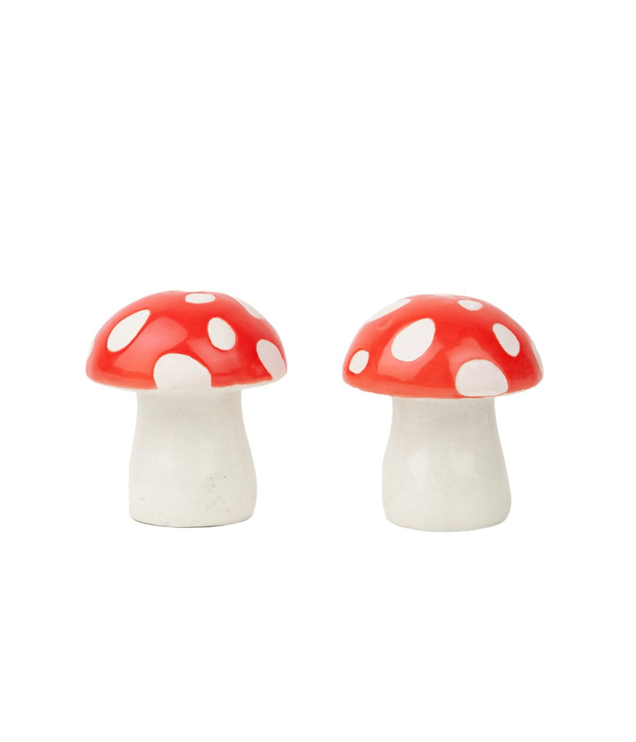 Due saliere e pepiere a forma di funghi decorativi rossi a pois bianchi, su uno sfondo bianco.